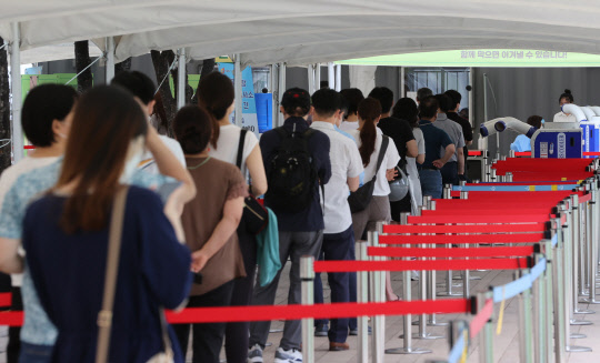 19일 오전 서울 서울시청 앞 임시선별검사소에서 시민들이 검사를 받기 위해 대기하고 있다.  연합뉴스